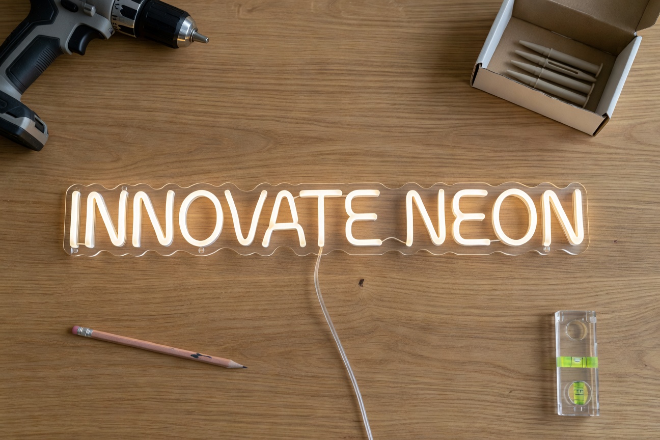 Tools for installing a LED neon sign: drill, wall plugs, level on a wooden table