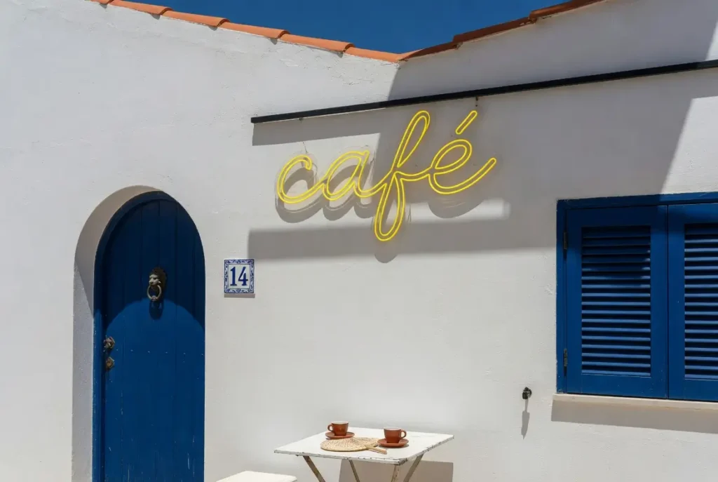 Letreiro neon LED de exterior em silicone anti-UV numa fachada de café no Algarve sob sol intenso, exemplo de resistência aos raios UV Helioneon